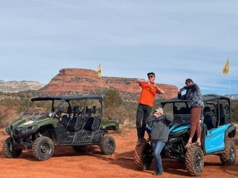 Group of UTV Rentals posing on a red rock off-road trail